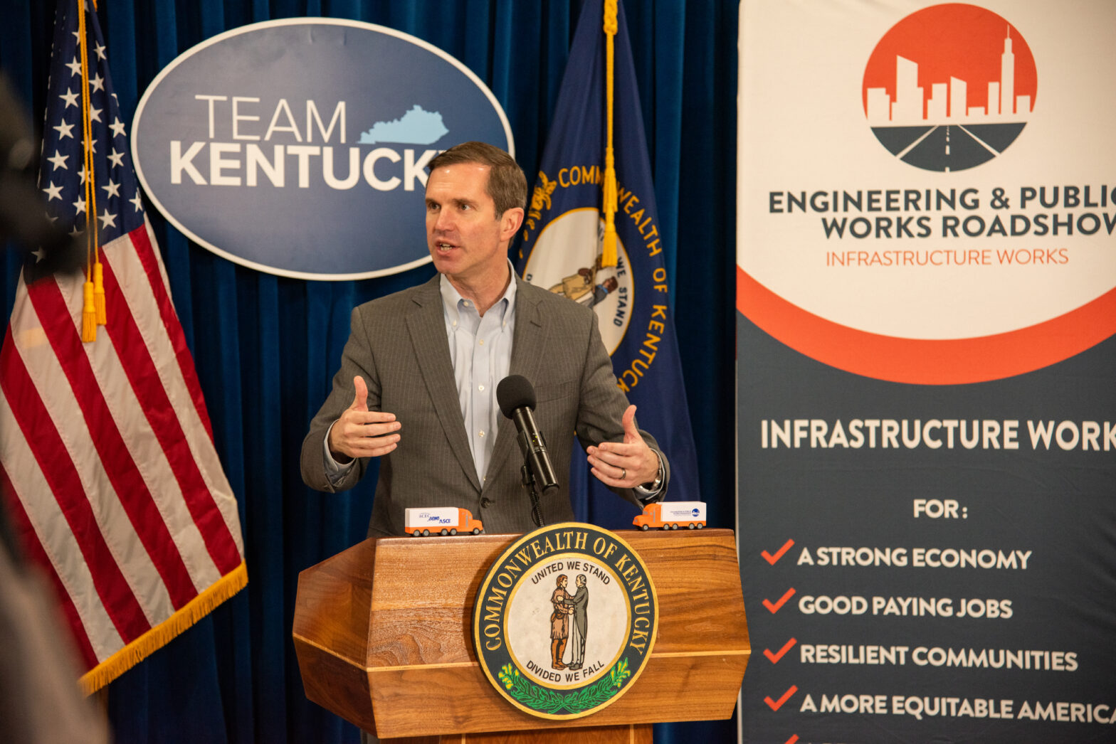 Kentucky Governor Andy Beshear speaks from a podium at the Roadshow stop.